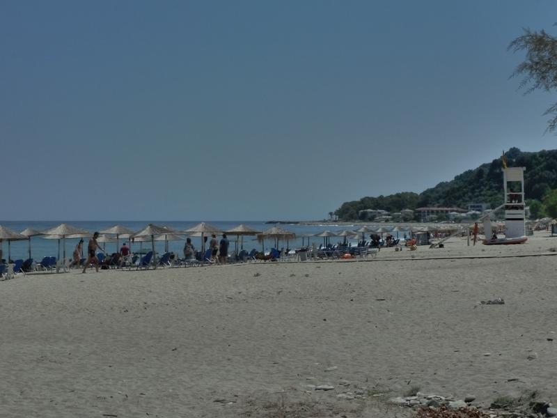 Swimmers on the huge beach of Chorefto, under the supervision of a lifeguard